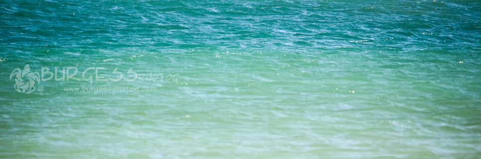 This is why the Emerald Coast of northwest Florida gets its name: waters along the beaches are a mix of aquamarine, shades of blue sapphire and emerald green, with a hint of smokey topaz during the winter months; photo by Charles Burgess; www.burgessphotog.com; Commercial – Conceptual -Lifestyle – Photography; All Rights Reserved.